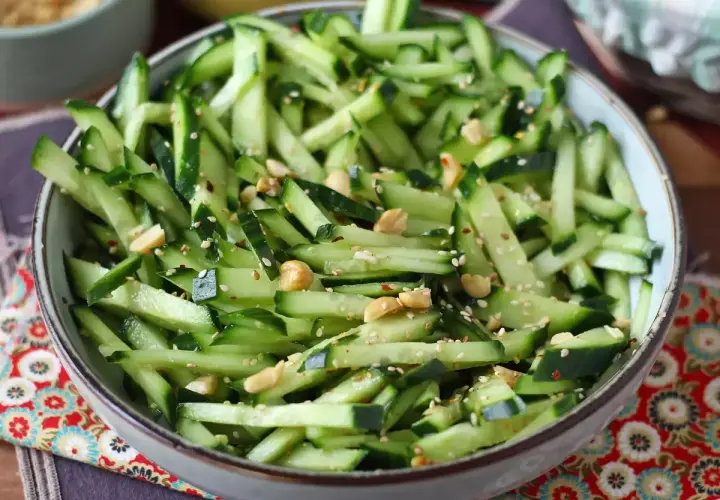 Una fresca insalata di cetrioli a julienne, condita con semi di sesamo, arachidi e peperoncino.