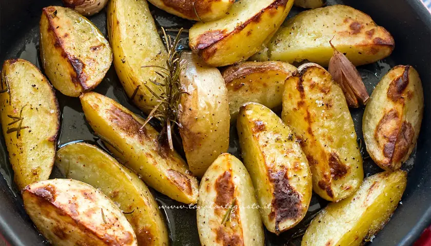 Patate al forno dorate e croccanti, condite con rosmarino e aglio, pronte per essere gustate.
