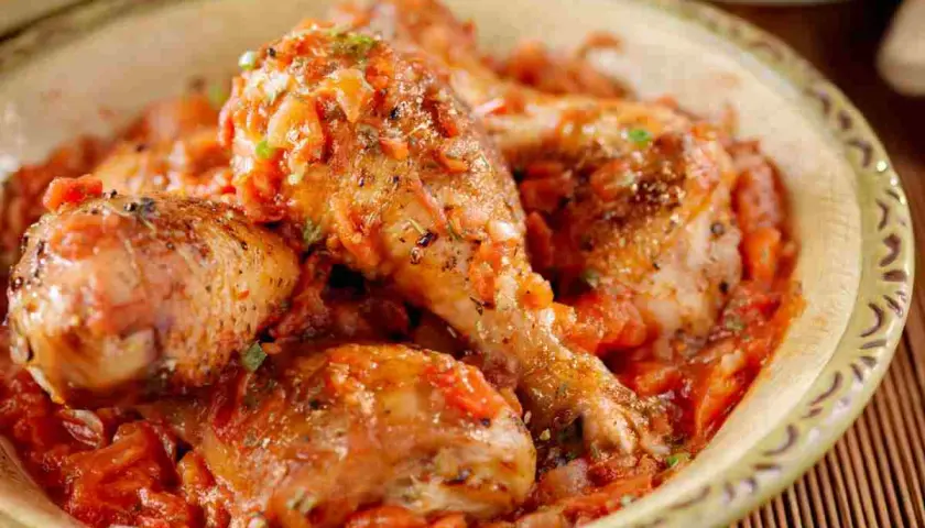 Pollo alla cacciatora succulento in una ciotola, con pezzi di pollo dorati immersi in un sugo rosso ricco di pomodoro e spezie.