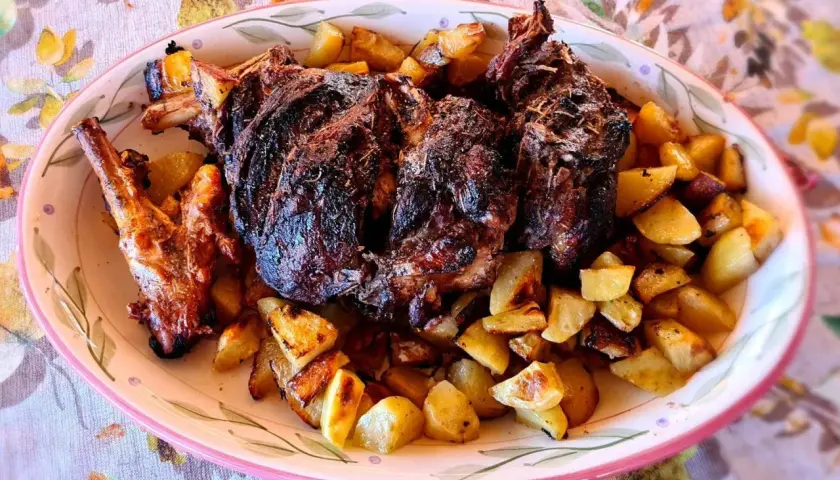 Un succulento agnello al forno con patate croccanti, un piatto che profuma di tradizione e famiglia.