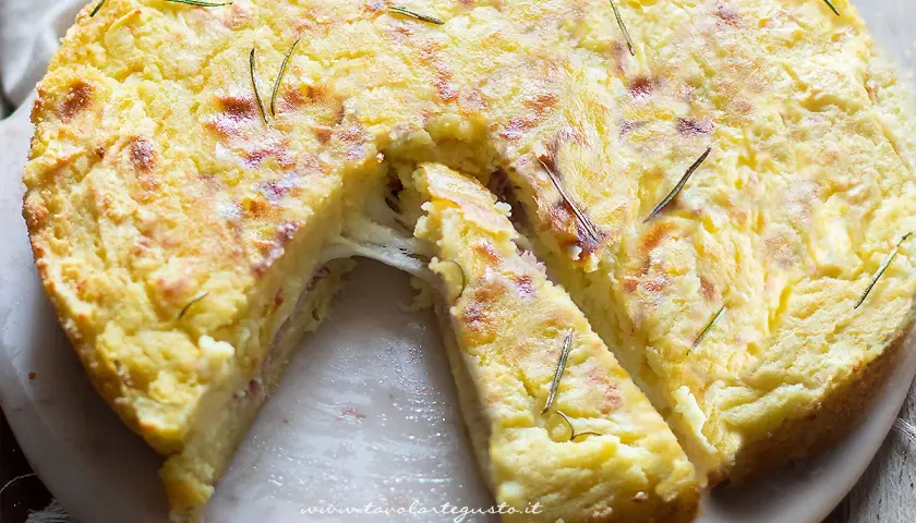 Torta salata con patate, filante e dorata, guarnita con rosmarino. Perfetta per un pranzo gustoso.