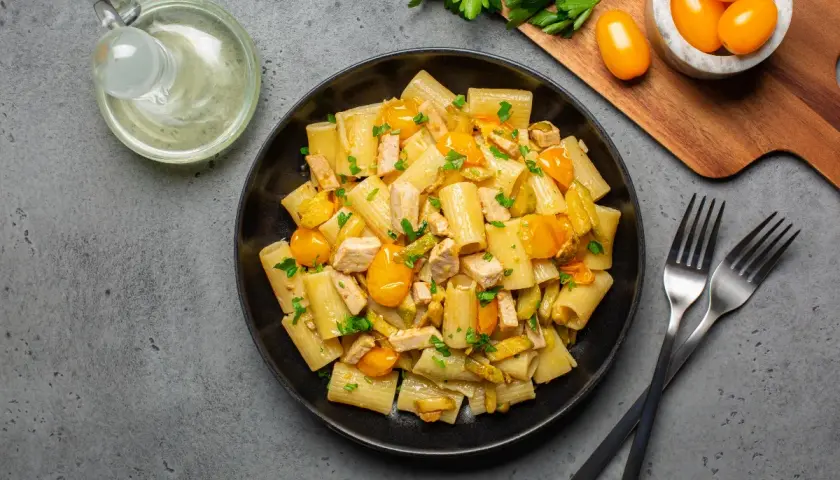 Piatto di pasta con pesce spada, pomodorini gialli e prezzemolo fresco. Un classico sapore mediterraneo.