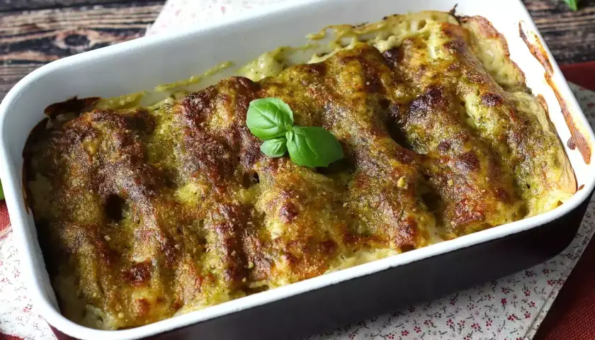 Cannelloni ricotta e spinaci appena sfornati, dorati e profumati, guarniti con una fogliolina di basilico fresco.