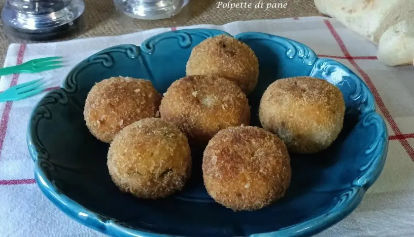 Sette polpette di pane dorate e croccanti, servite su un piatto blu. Perfette per uno spuntino gustoso.