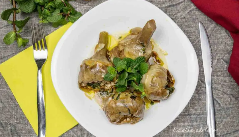 Un piatto invitante di carciofi alla romana, teneri e profumati, guarniti con menta fresca.