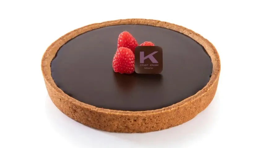 Deliziosa crostata al cioccolato con lamponi freschi e il logo di Ernst Knam.