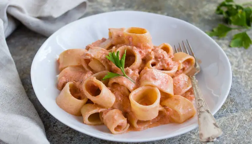 Un piatto invitante di pasta al tonno con una cremosa salsa rosa, guarnito con prezzemolo fresco.