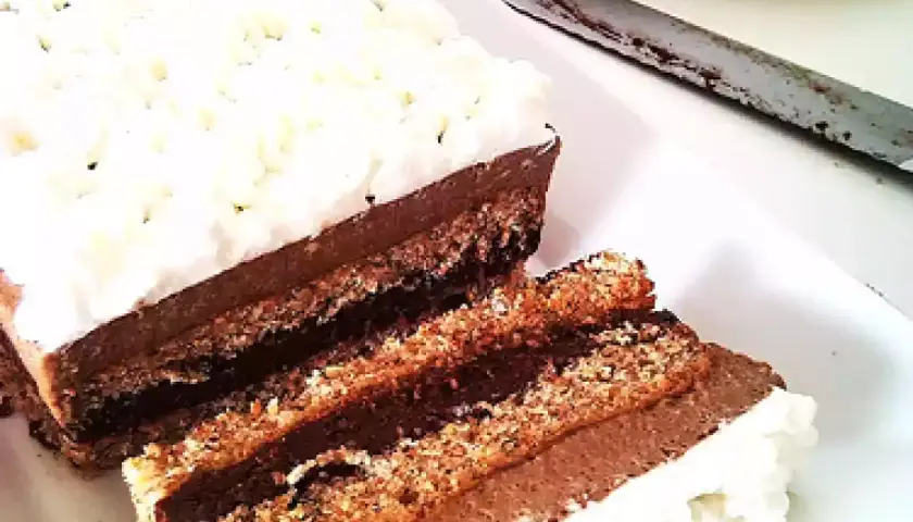 Deliziosa bavarese al cioccolato con strati di pan di Spagna e crema al cacao, guarnita con panna montata.