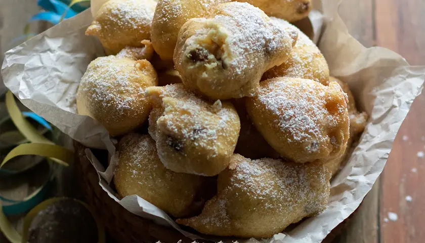 Frittelle di una volta, dolci e soffici, cosparse di zucchero a velo, perfette per un momento di golosità.