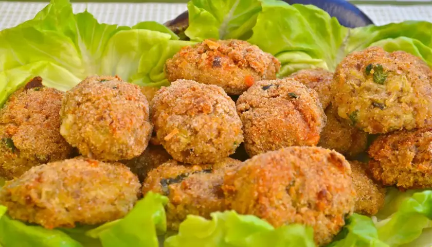 Polpette di melanzane dorate e croccanti, servite su un letto di lattuga fresca. Un antipasto gustoso e leggero.