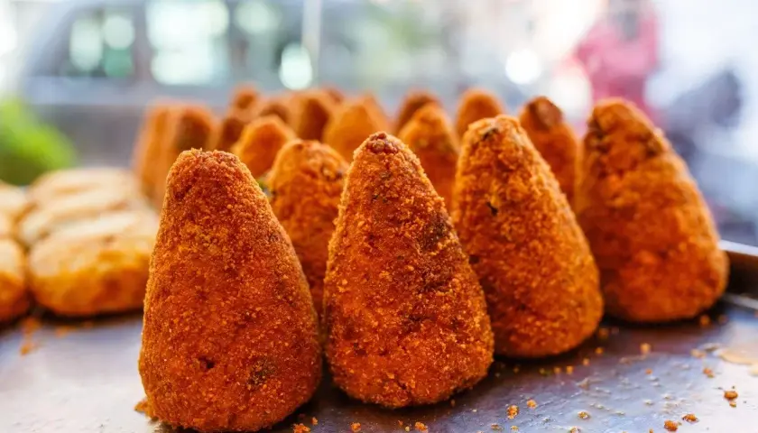 Arancini dorati e croccanti, un classico street food siciliano. Perfetti per uno spuntino goloso.