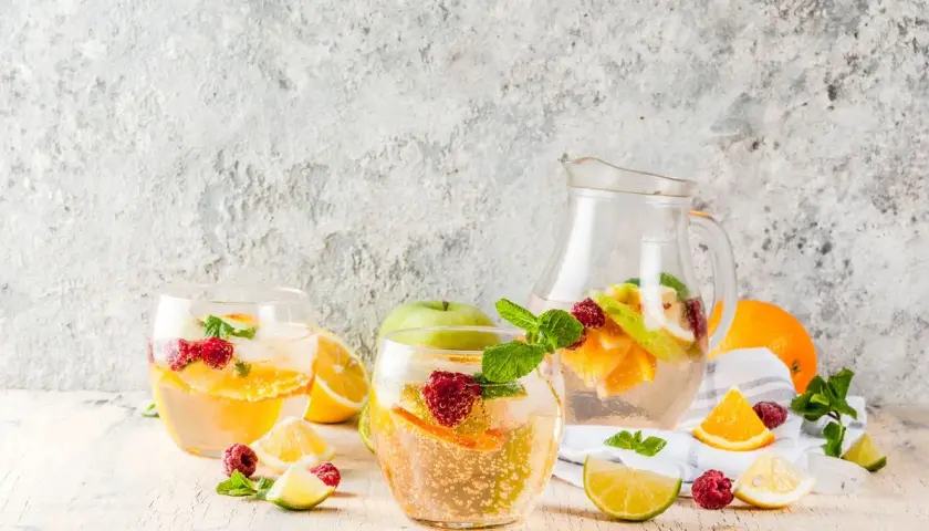 Sangria bianca ricetta: bicchieri e caraffa pieni di frutta fresca, ghiaccio e menta. Perfetta per l'estate!