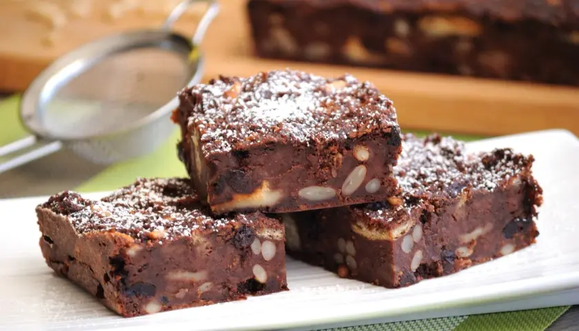 Fette di torta di pane al cioccolato, ricche di frutta secca e mandorle, spolverate di zucchero a velo.