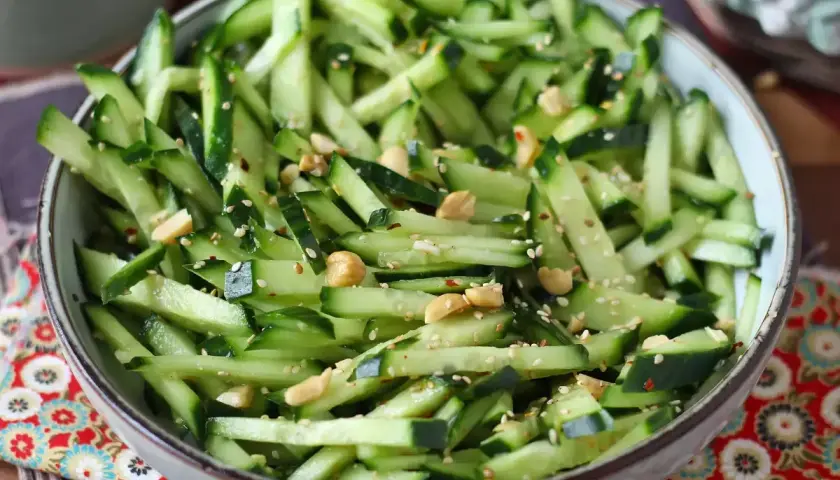Una fresca insalata di cetrioli a julienne, condita con semi di sesamo, arachidi e peperoncino.