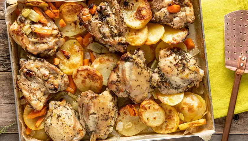 Sovracosce di pollo dorate e succulente, cotte al forno con patate, carote e sedano. Un piatto saporito e invitante.
