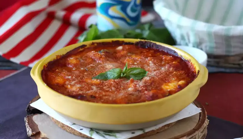 Gnocchi alla sorrentina appena sfornati, dorati e filanti, con basilico fresco. Un piatto invitante e saporito.