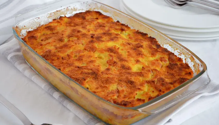 Gateau di patate ricetta: tortino dorato e croccante in pirofila di vetro, pronto per essere servito.