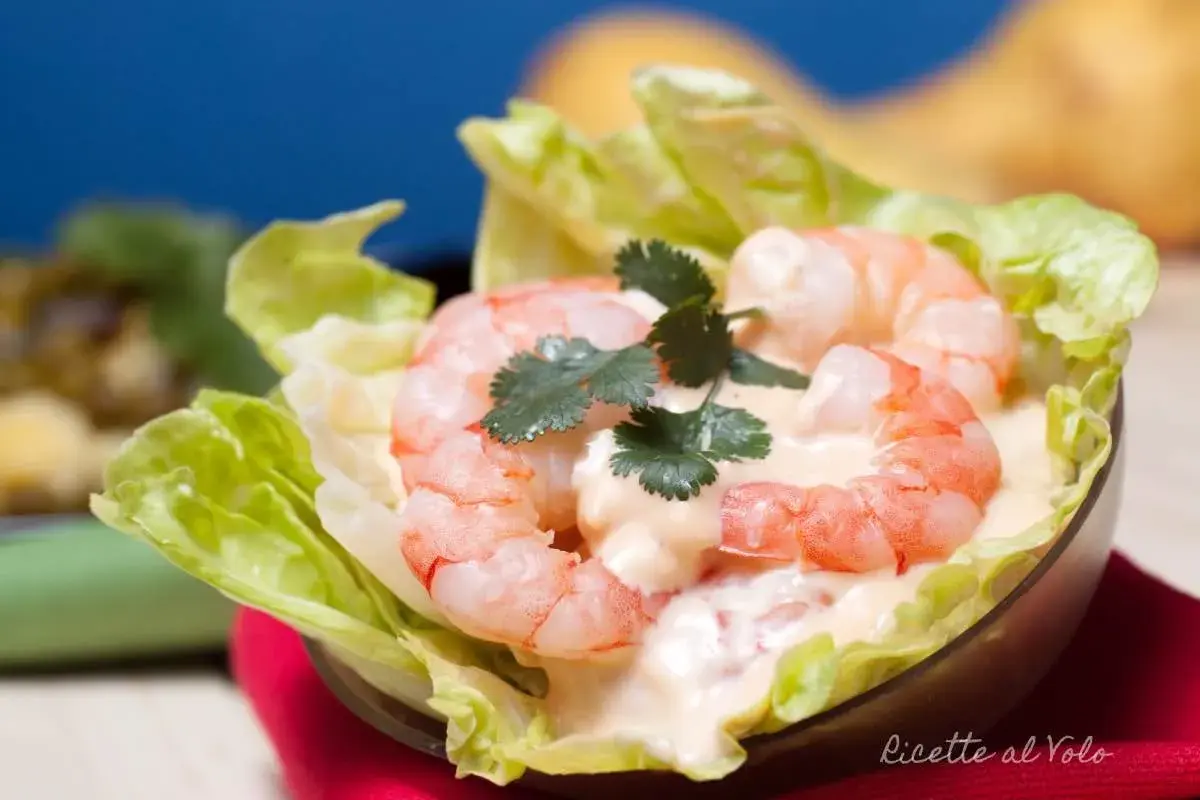 Gamberetti succulenti in salsa rosa cremosa, serviti su foglie di lattuga croccante. Un antipasto fresco e invitante.