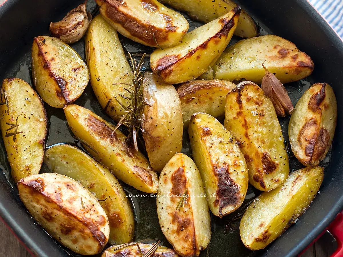 Patate al forno dorate e croccanti, condite con rosmarino e aglio, pronte per essere gustate.