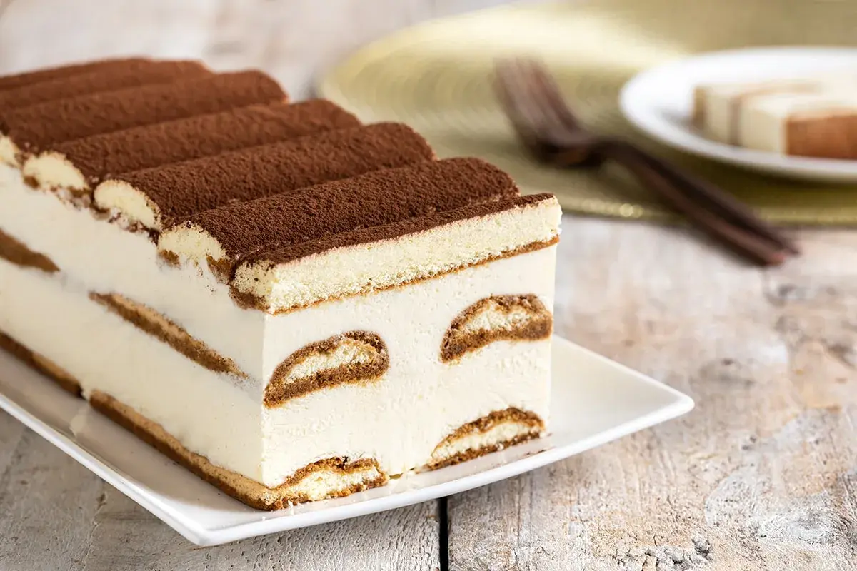 Tiramisù cremoso e soffice, un dolce senza glutine perfetto per ogni occasione. Strati di savoiardi senza glutine e crema al mascarpone, spolverato di cacao.