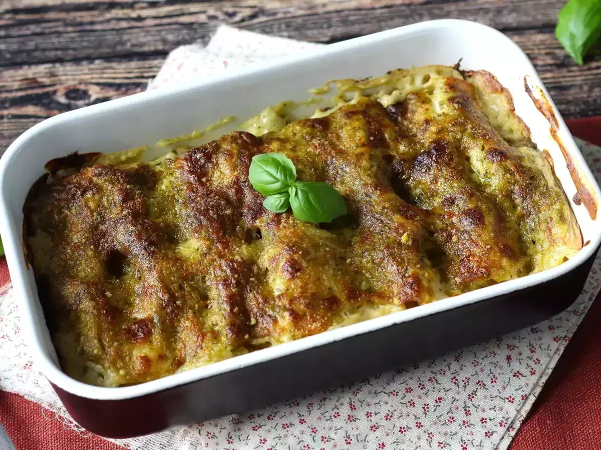 Cannelloni ricotta e spinaci appena sfornati, dorati e profumati, guarniti con una fogliolina di basilico fresco.