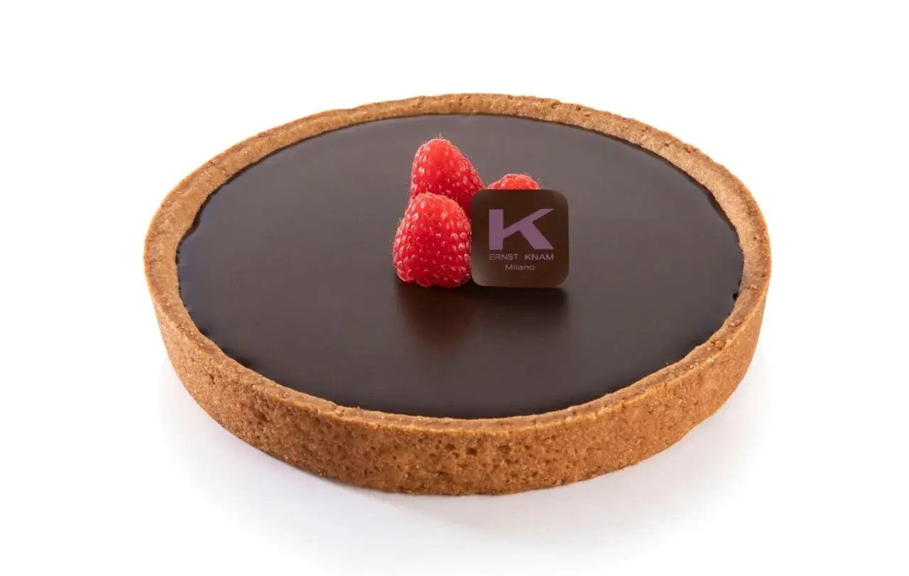 Deliziosa crostata al cioccolato con lamponi freschi e il logo di Ernst Knam.