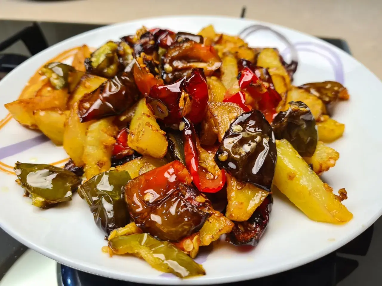 Un piatto invitante di **pipi e patate** saltate, con peperoni verdi e rossi croccanti e patate dorate, condite con spezie.