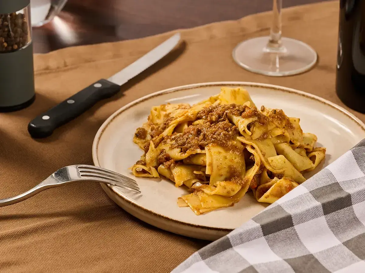 Piatto di pappardelle al cinghiale, un classico della cucina toscana, pronto per essere gustato.