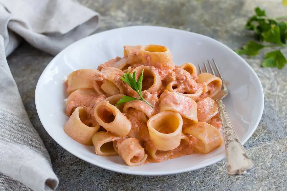 Un piatto invitante di pasta al tonno con una cremosa salsa rosa, guarnito con prezzemolo fresco.