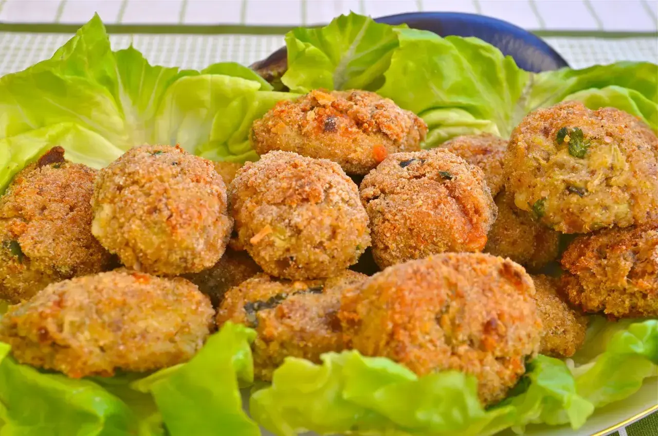 Polpette di melanzane dorate e croccanti, servite su un letto di lattuga fresca. Un antipasto gustoso e leggero.