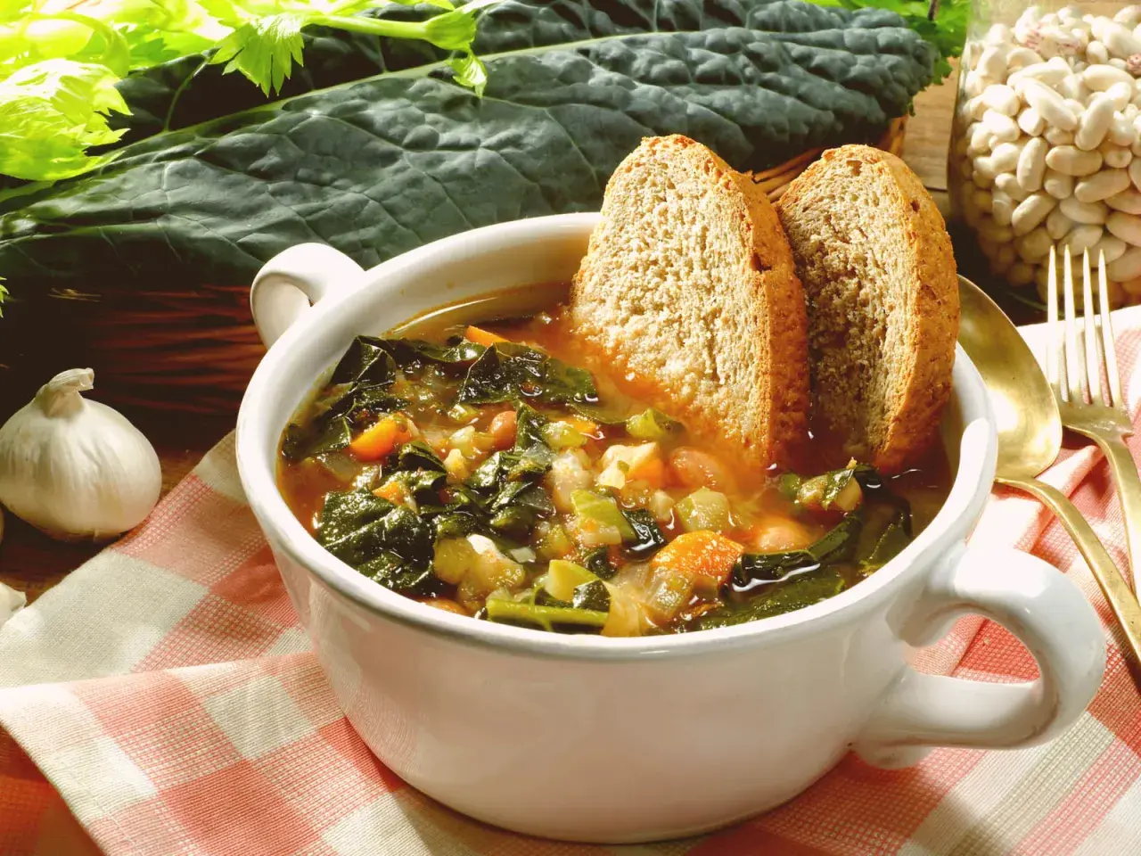 Una ciotola fumante di zuppa di cavolo nero, con pane tostato e fagioli, pronta per essere gustata.