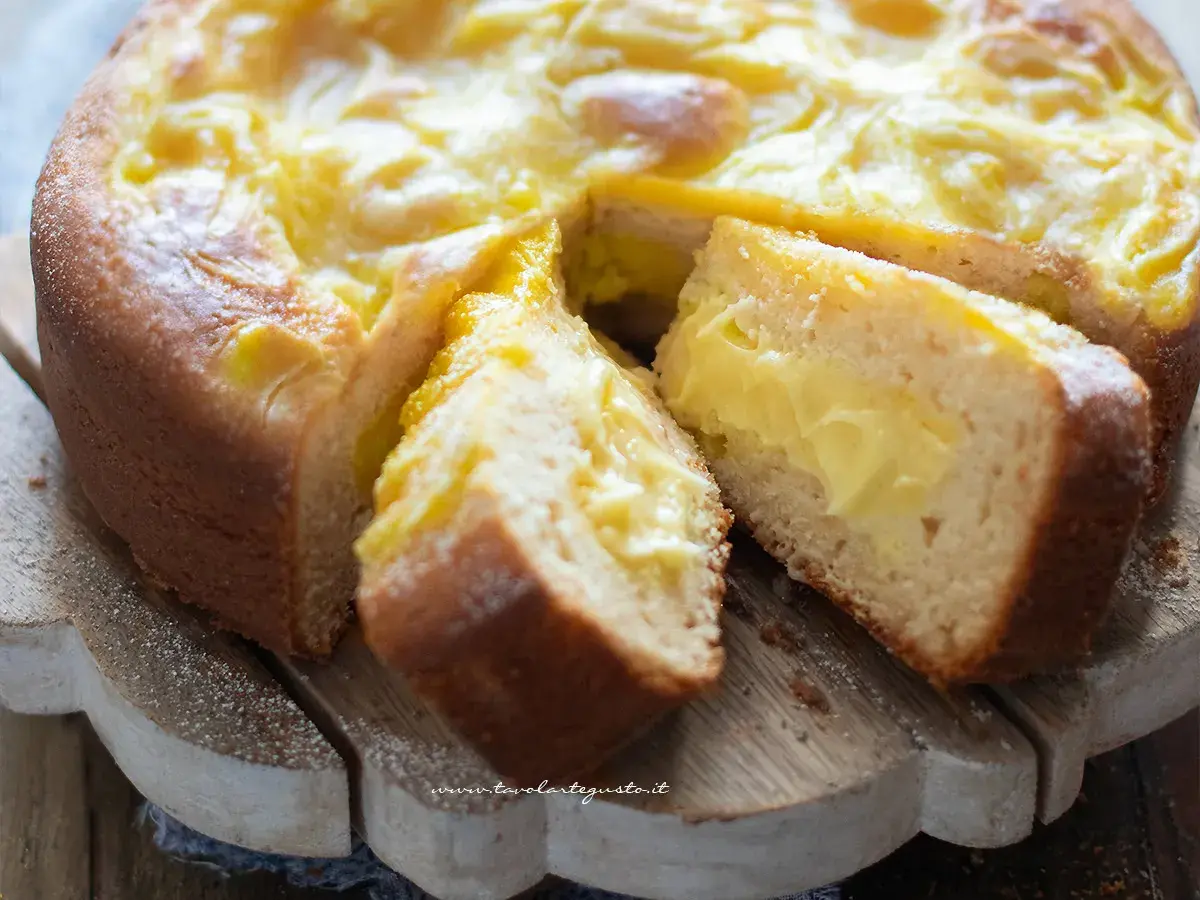 Torta al limone velocissima con crema gialla e soffice impasto, tagliata a fette su un tagliere di legno.