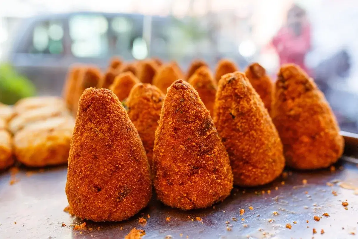 Arancini dorati e croccanti, un classico street food siciliano. Perfetti per uno spuntino goloso.