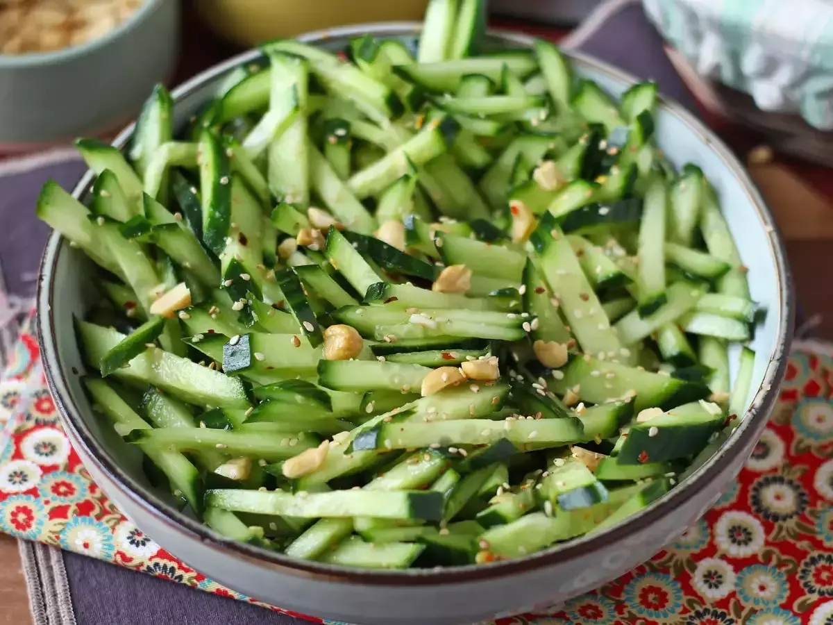 Una fresca insalata di cetrioli a julienne, condita con semi di sesamo, arachidi e peperoncino.