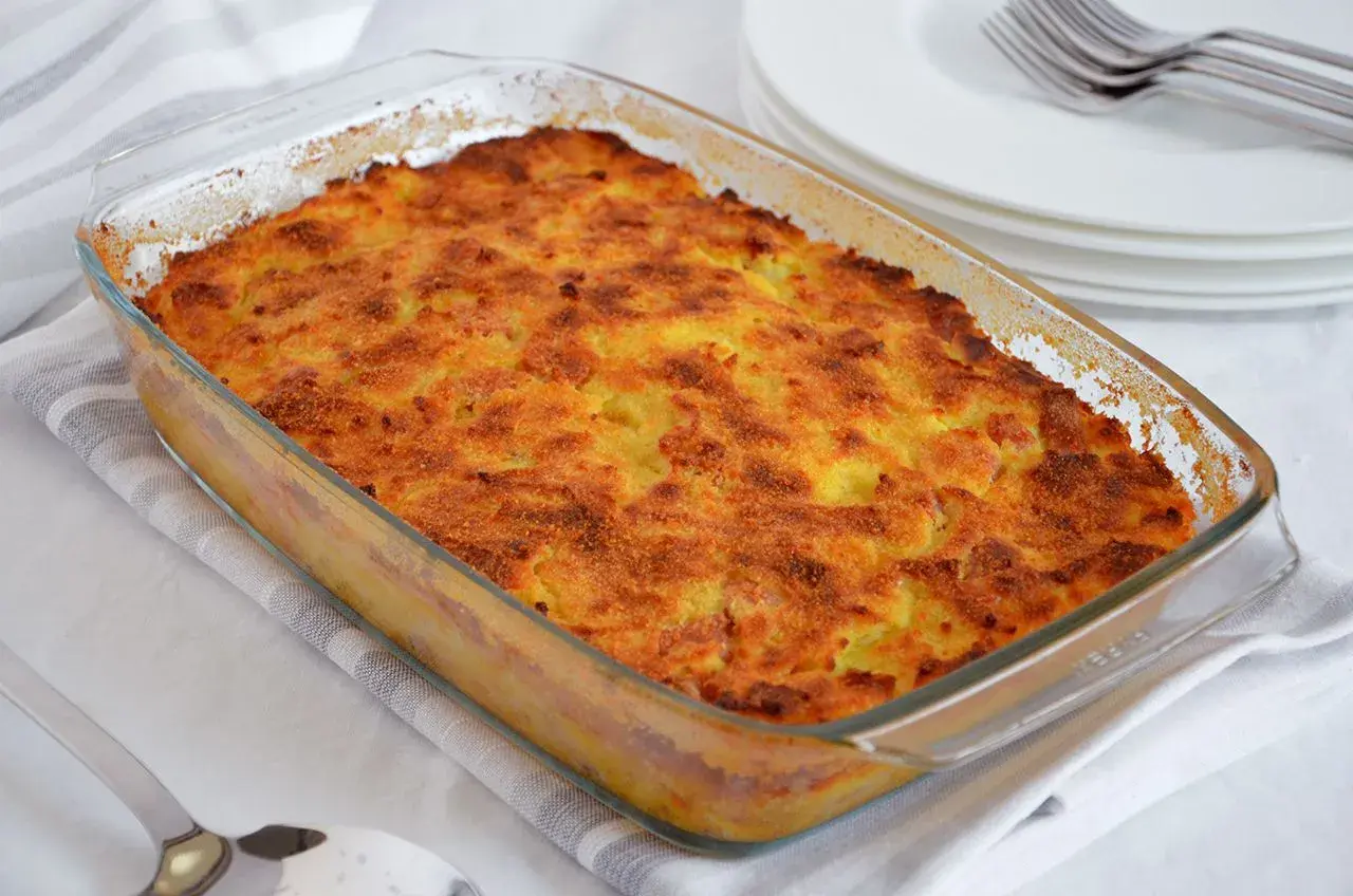 Gateau di patate ricetta: tortino dorato e croccante in pirofila di vetro, pronto per essere servito.