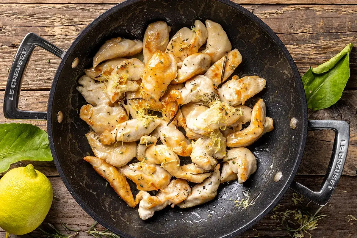 Straccetti di pollo saporiti cotti in padella, conditi con scorza di limone e erbe aromatiche.