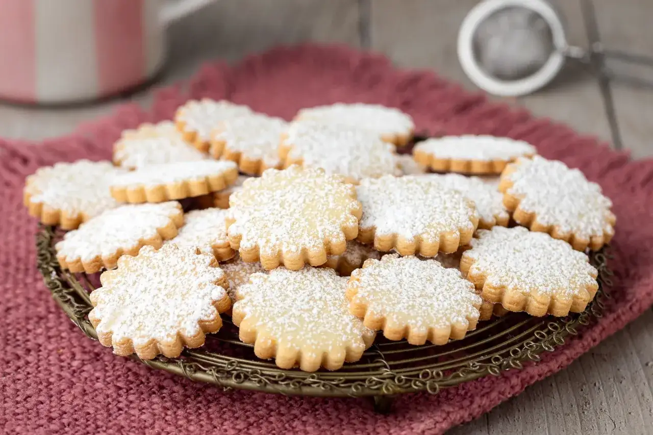 Un mucchio di biscotti classici, spolverati di zucchero a velo, pronti per essere gustati.