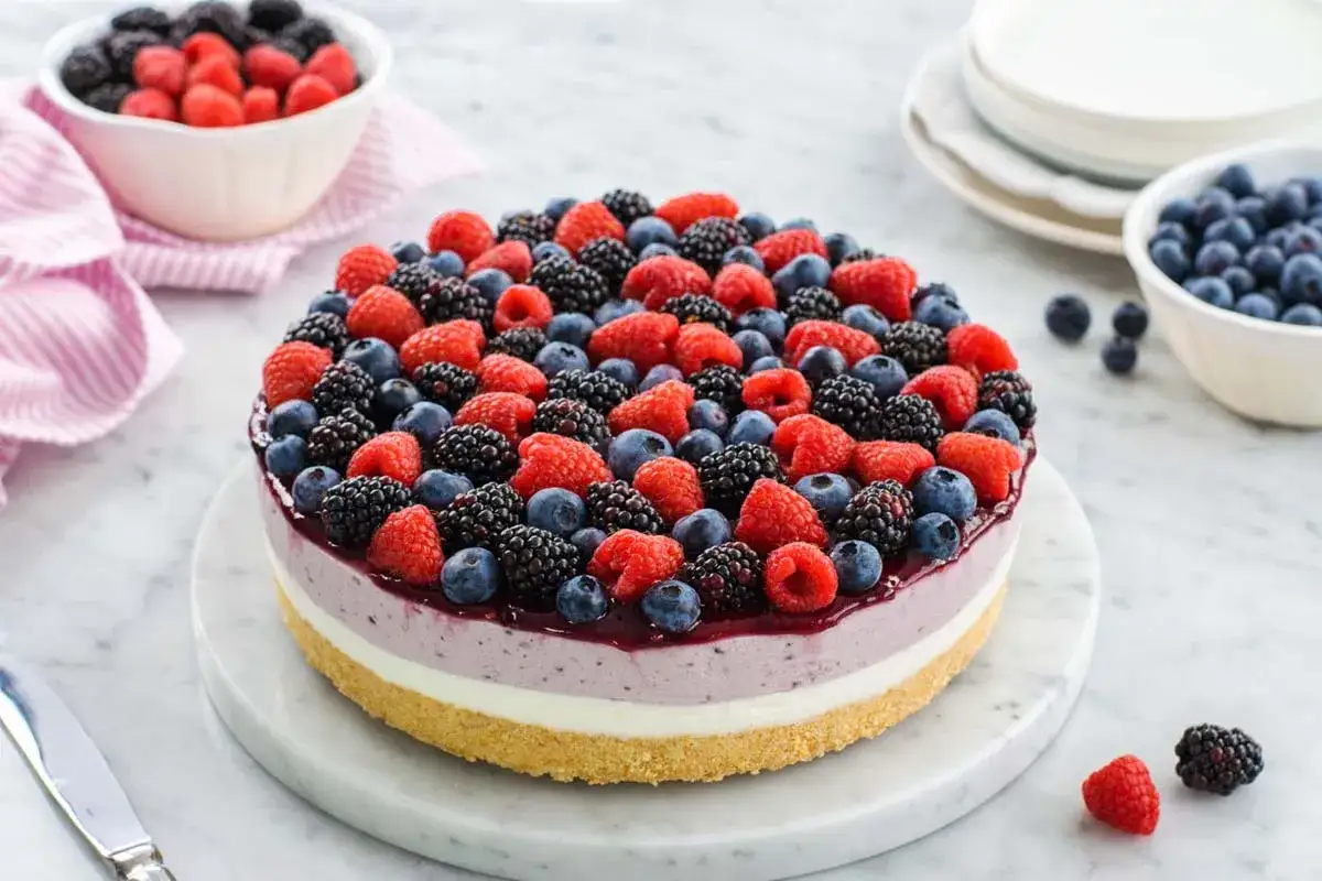 Cheesecake ai frutti di bosco, un tripudio di lamponi, mirtilli e more su una base croccante, pronto per essere gustato.