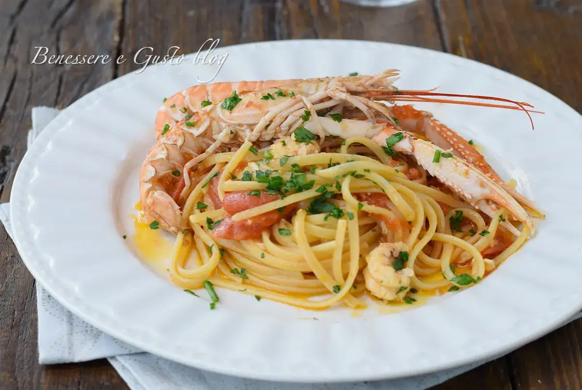 Un piatto di linguine agli scampi, con pomodorini e prezzemolo fresco, pronto per essere gustato.