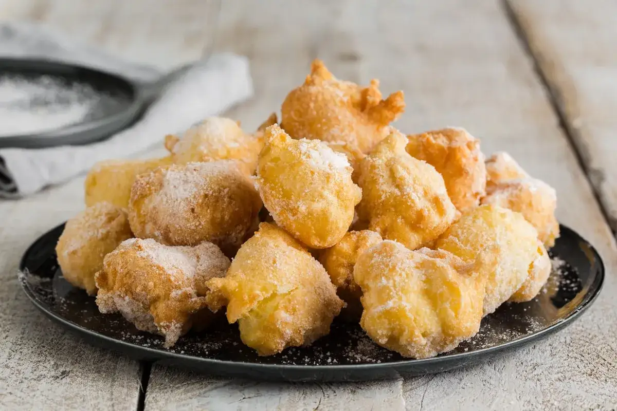 Frittelle di una volta, soffici e dorate, cosparse di zucchero a velo. Un dolce che profuma di tradizione e ricordi felici.