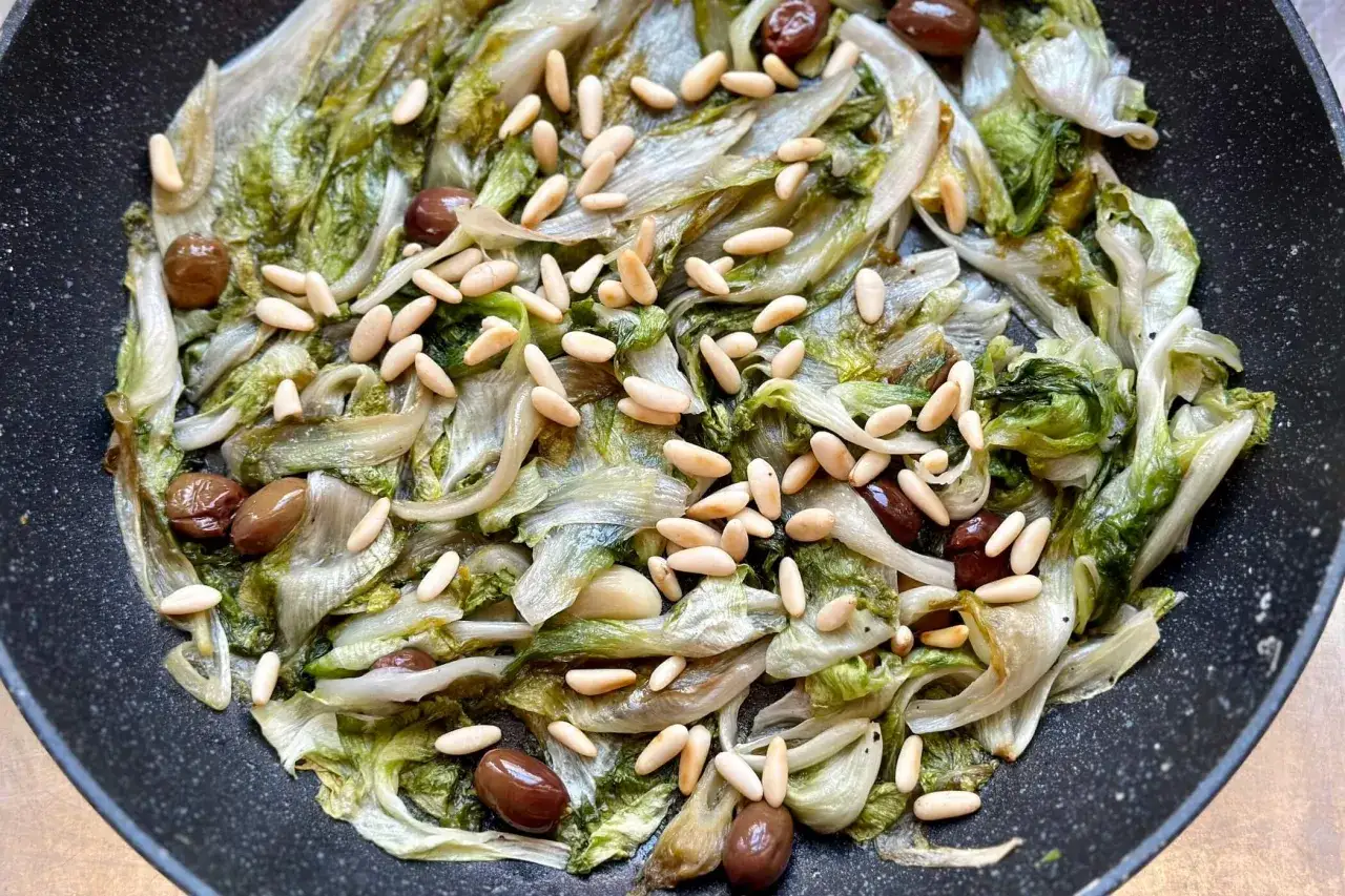 Scarola in padella con olive e pinoli, un contorno saporito e leggero.