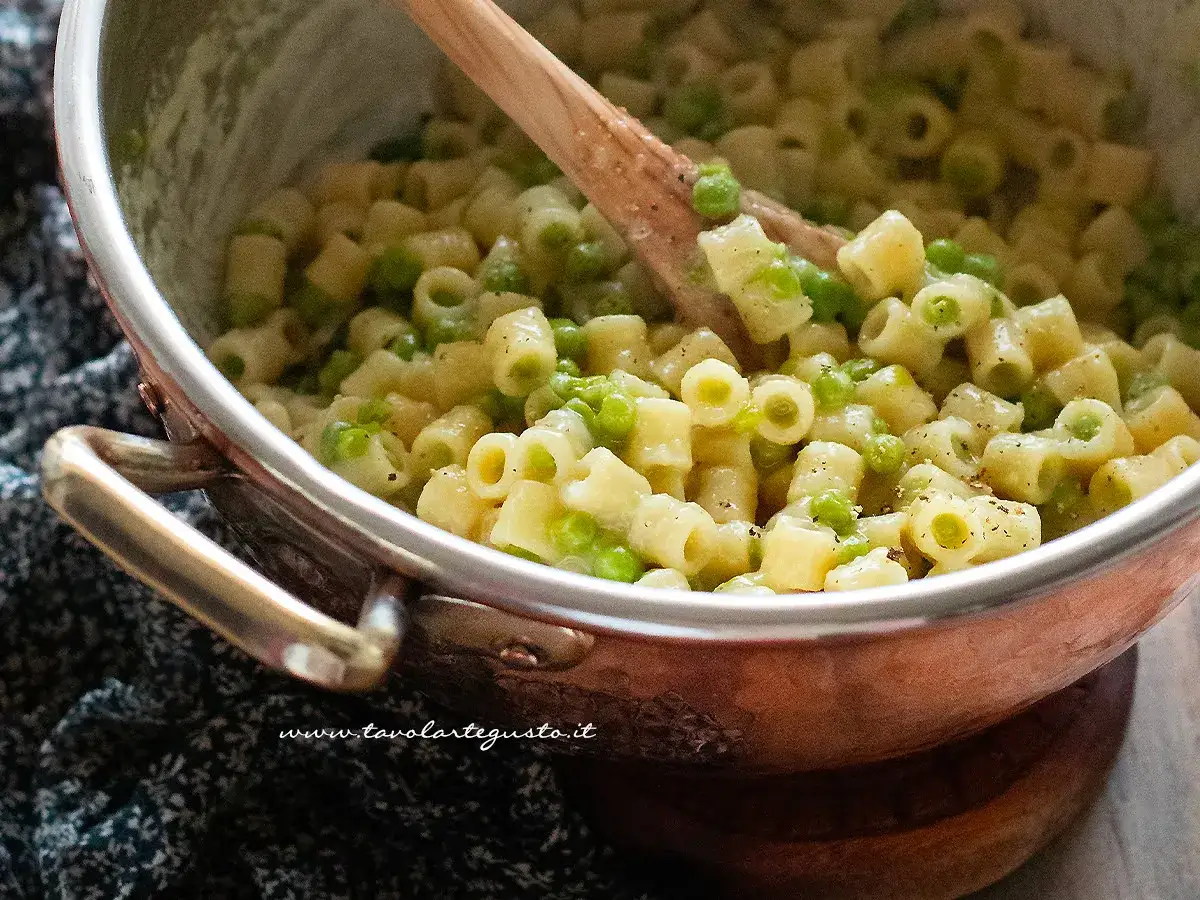 Un primo piatto cremoso di pasta e piselli, pronto per essere gustato.