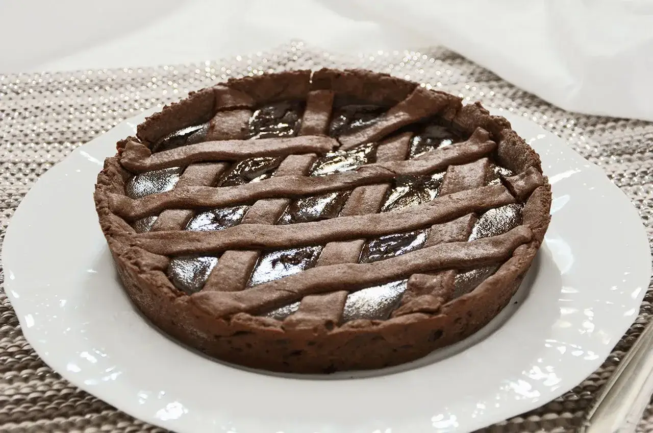 Deliziosa crostata al cioccolato con una griglia di pasta frolla scura e un ripieno lucido e invitante.