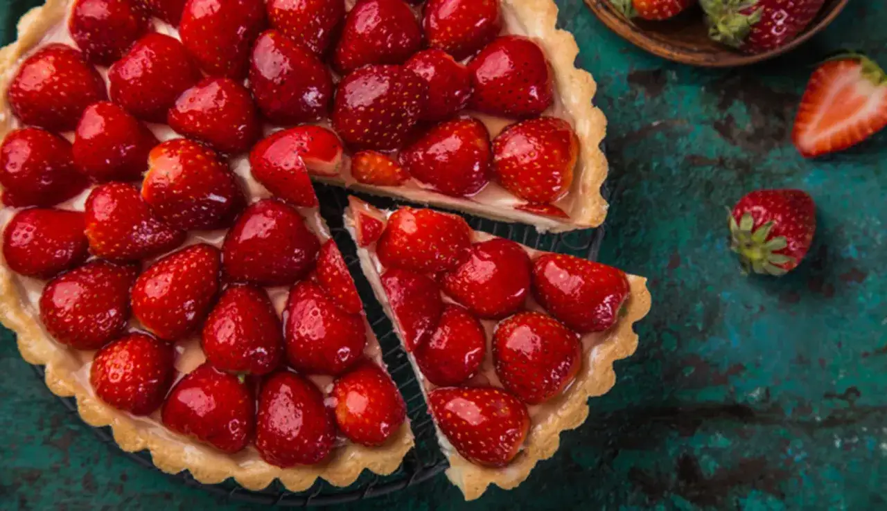 Una deliziosa crostata di frutta, con tante fragole rosse e succose su una base dorata.