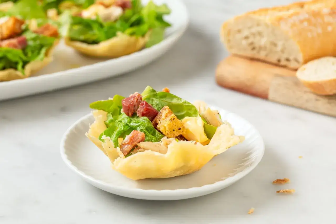 Deliziosi cestini di parmigiano ripieni di insalata croccante, pollo e crostini.