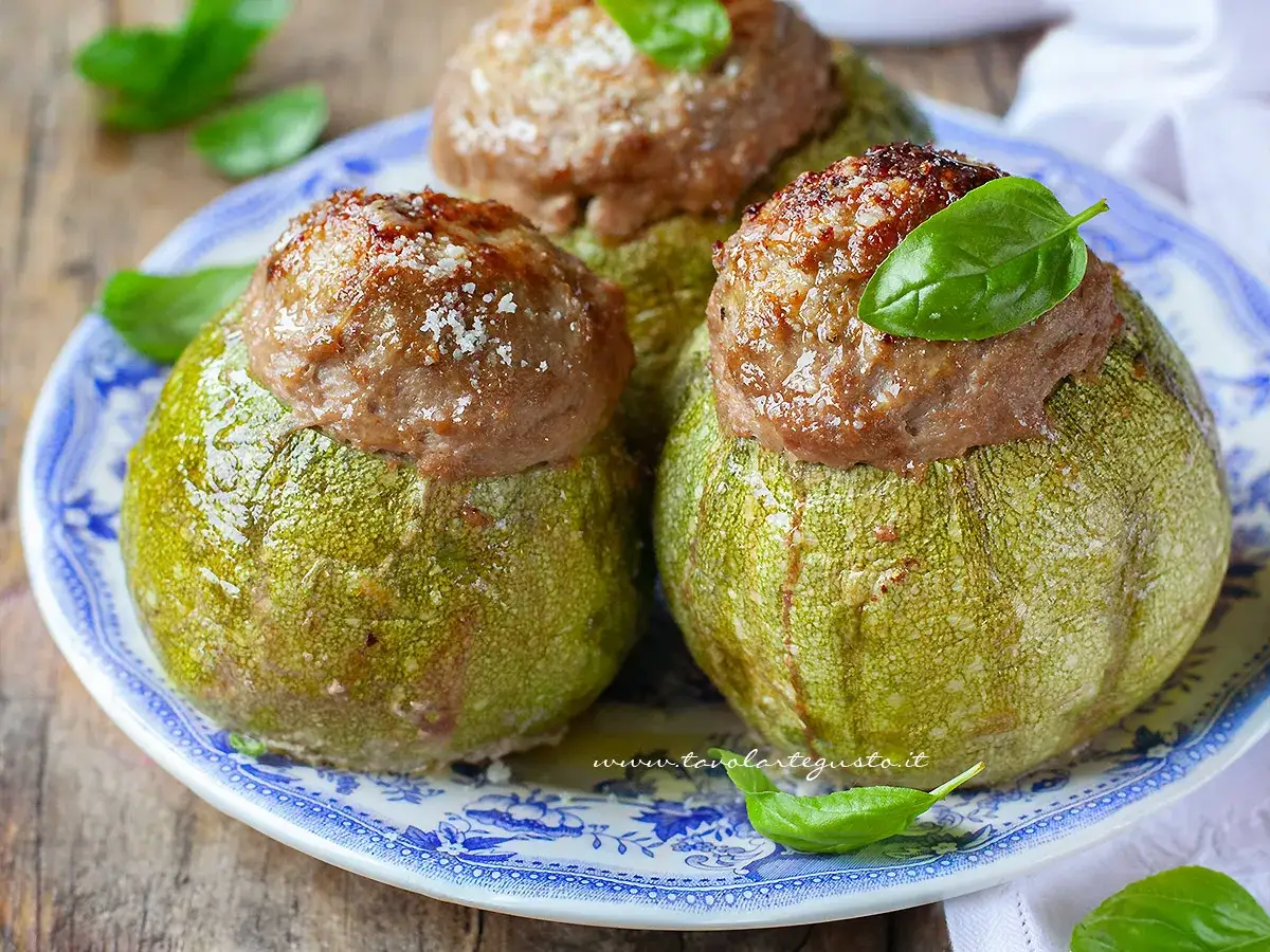Zucchine tonde ripiene, un piatto gustoso e colorato, con un ripieno saporito e una fogliolina di basilico a guarnire.