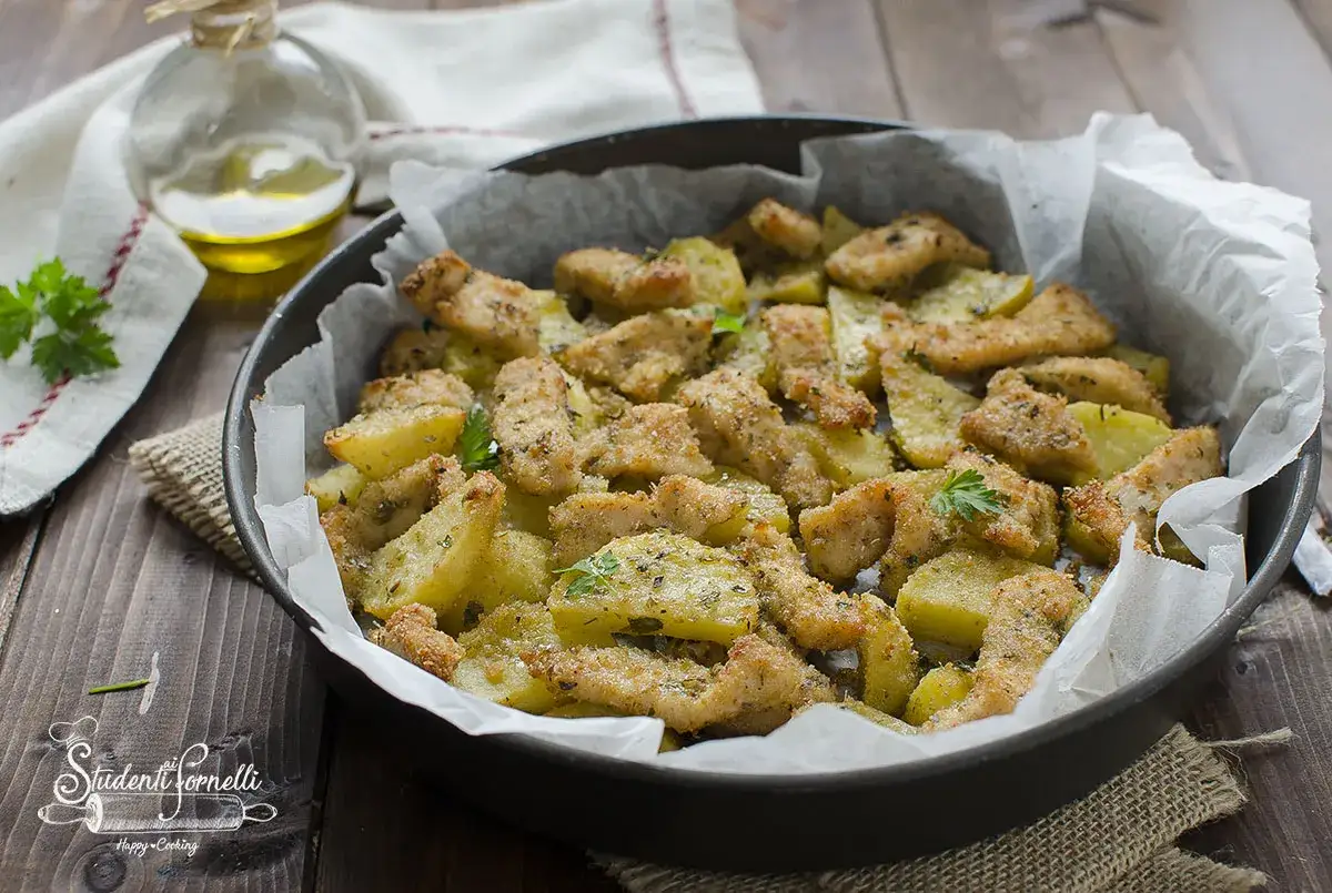 Straccetti di pollo al forno con patate, dorati e croccanti, un piatto semplice e gustoso.