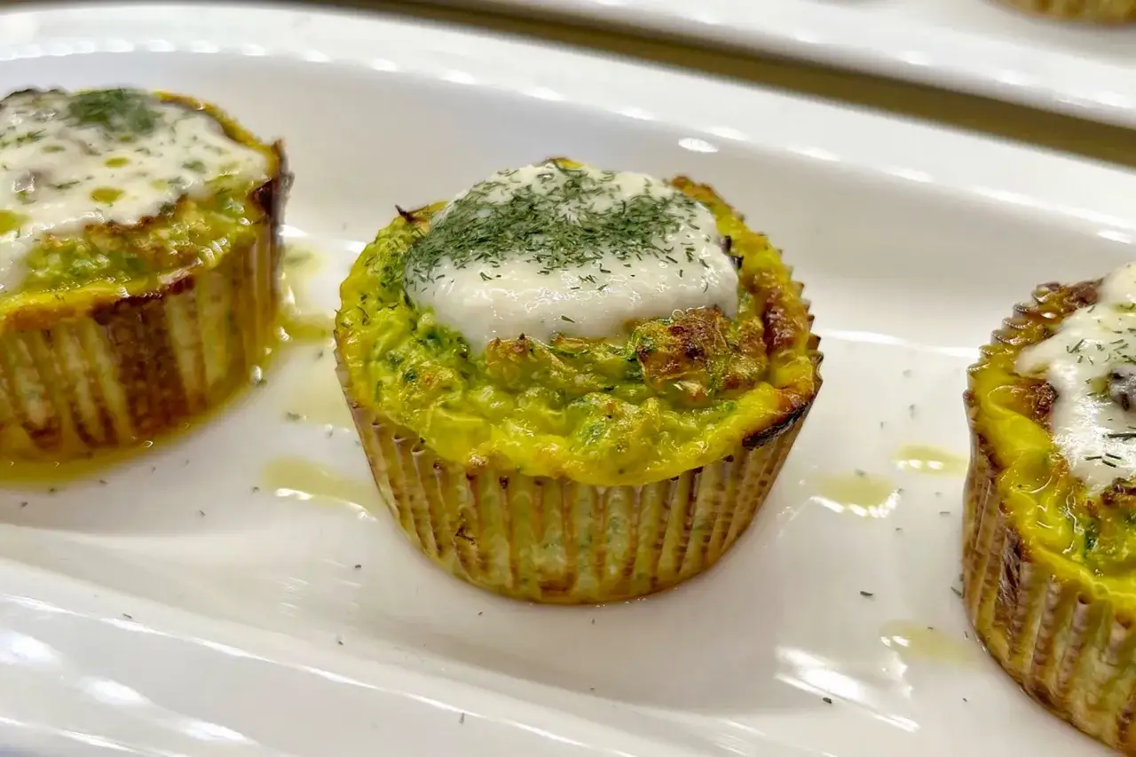Deliziosi flan di zucchine, dorati e guarniti con erbe aromatiche e una spolverata di formaggio fuso.