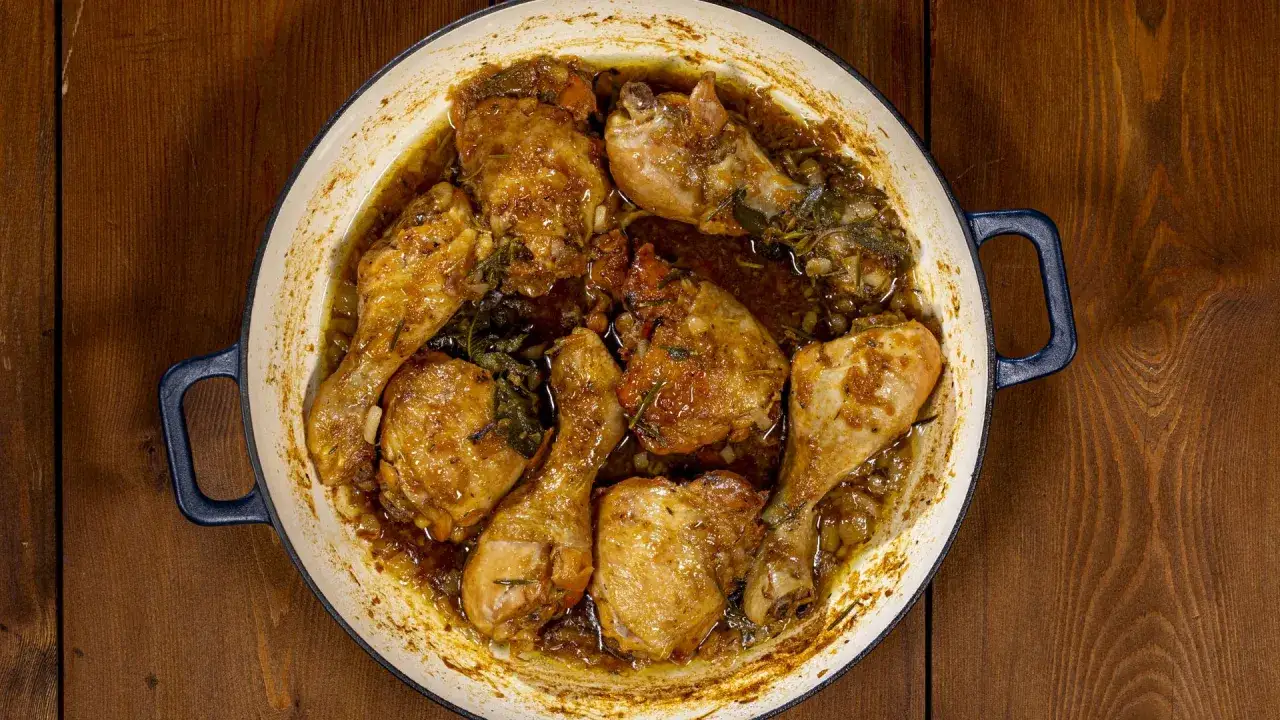 Succulento pollo alla birra cotto in tegame, con erbe aromatiche e una salsa dorata.