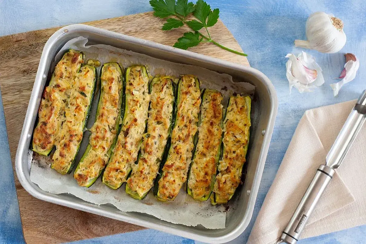 Zucchine ripiene alla ligure, dorate al forno, pronte per essere gustate. Un piatto saporito e leggero.